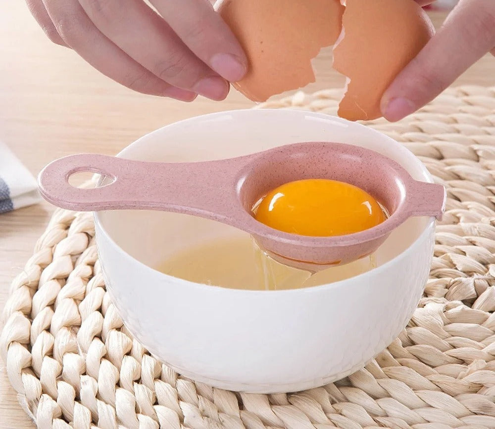 An egg cracked into the pink separator resting on the rim of a bowl