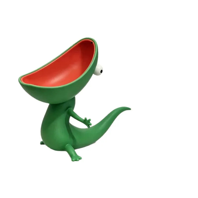Green lizard soap dish on a plain white background, showing the empty coral-red mouth and the single white eye
