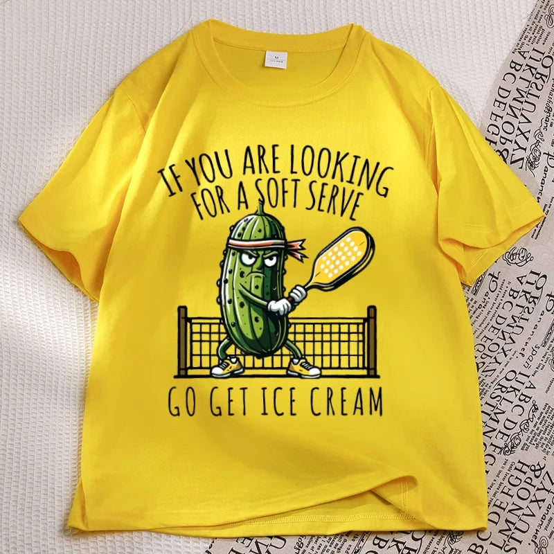 Yellow pickleball tee laid flat, cartoon pickle with a paddle printed on the chest