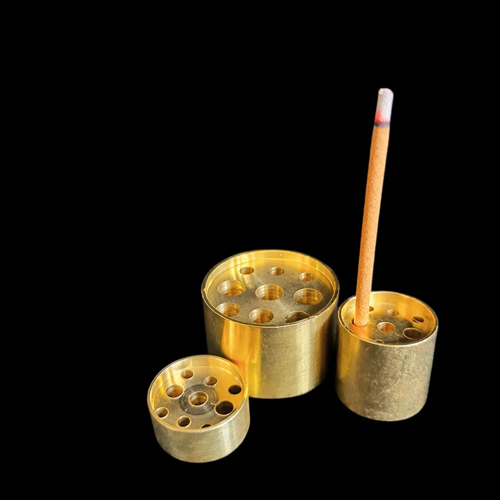 A drilled barrel and a drilled disc side by side on black, with an incense stick standing upright in one - the incense is not included