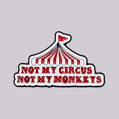 Red and white circus tent enamel pin reading not my circus not my monkeys
