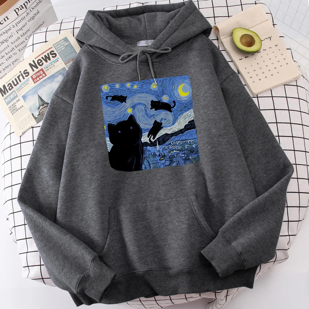 Dark grey fleece pullover hoodie with a large front print of a swirling starry night sky, a crescent moon and black cats over a village