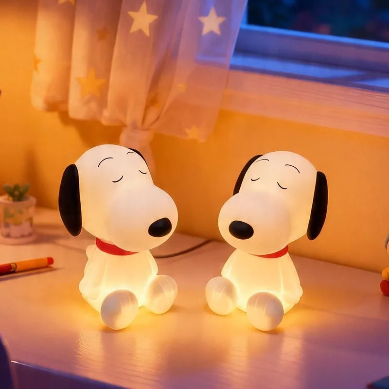 Two of the cartoon dog lamps lit side by side on a windowsill under a star-patterned curtain, showing the shape from both sides