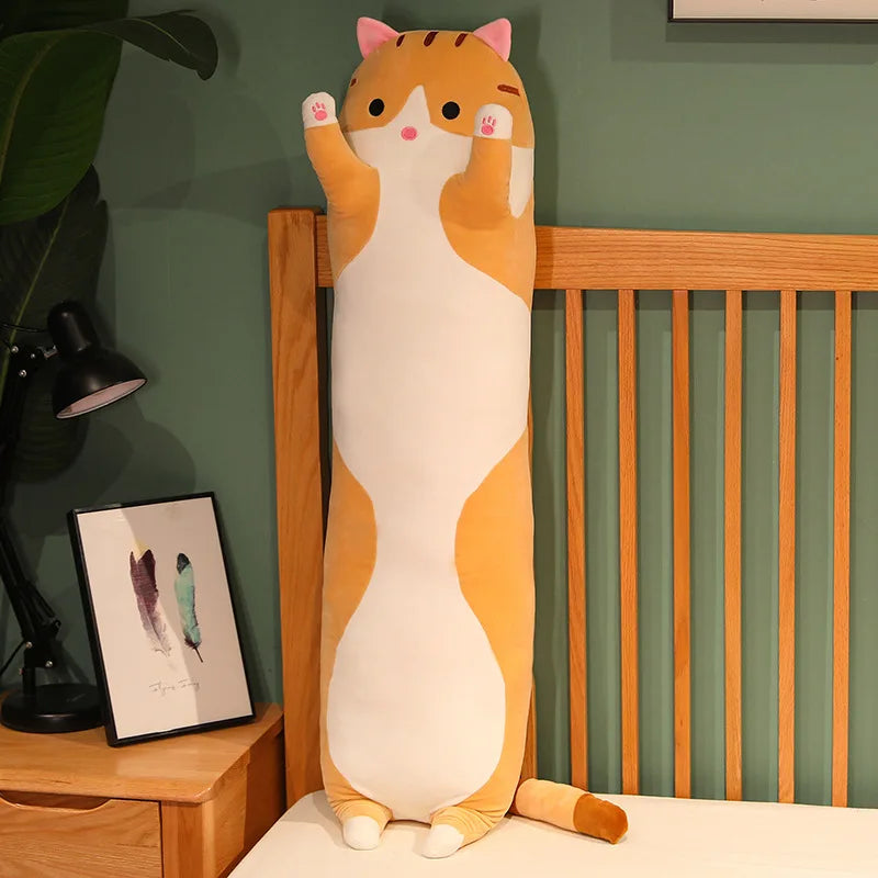 Ginger tabby long cat body pillow standing upright against a bed frame