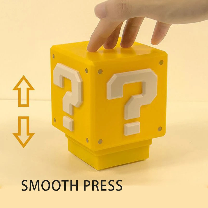 The unlit yellow cube with a hand resting on its top face, labelled smooth press with up and down arrows showing the top travels
