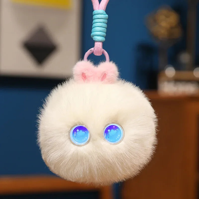 Cream white fluffy pom-pom charm with round blue light-up eyes, hanging from its cord