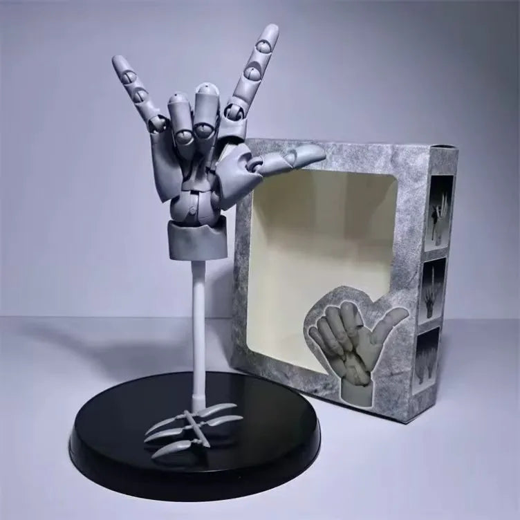 Grey right hand model held in a horned hand sign, on its stand beside the window box