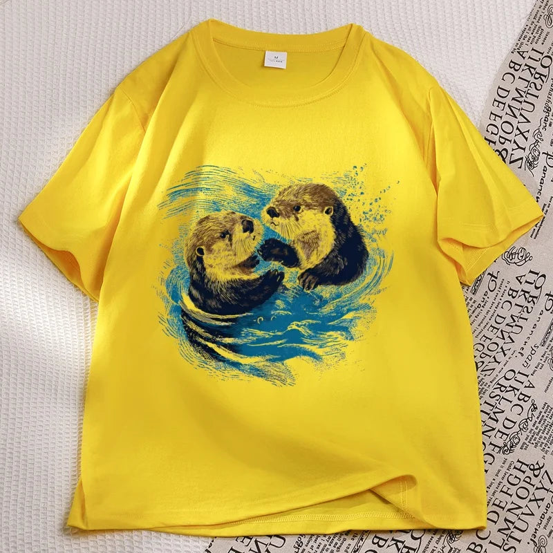 Yellow sea otter tee laid flat, two otters printed on the chest