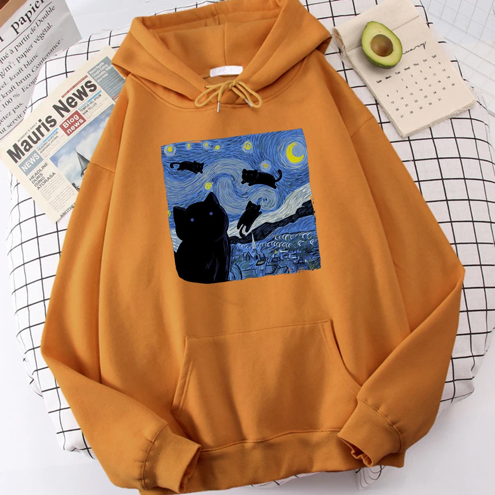 Khaki fleece pullover hoodie with a large front print of a swirling starry night sky, a crescent moon and black cats over a village
