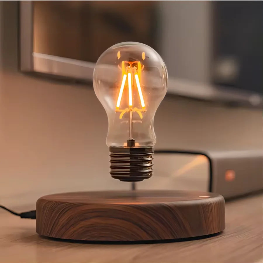The lamp lit warm on a round base, mains lead running off the desk