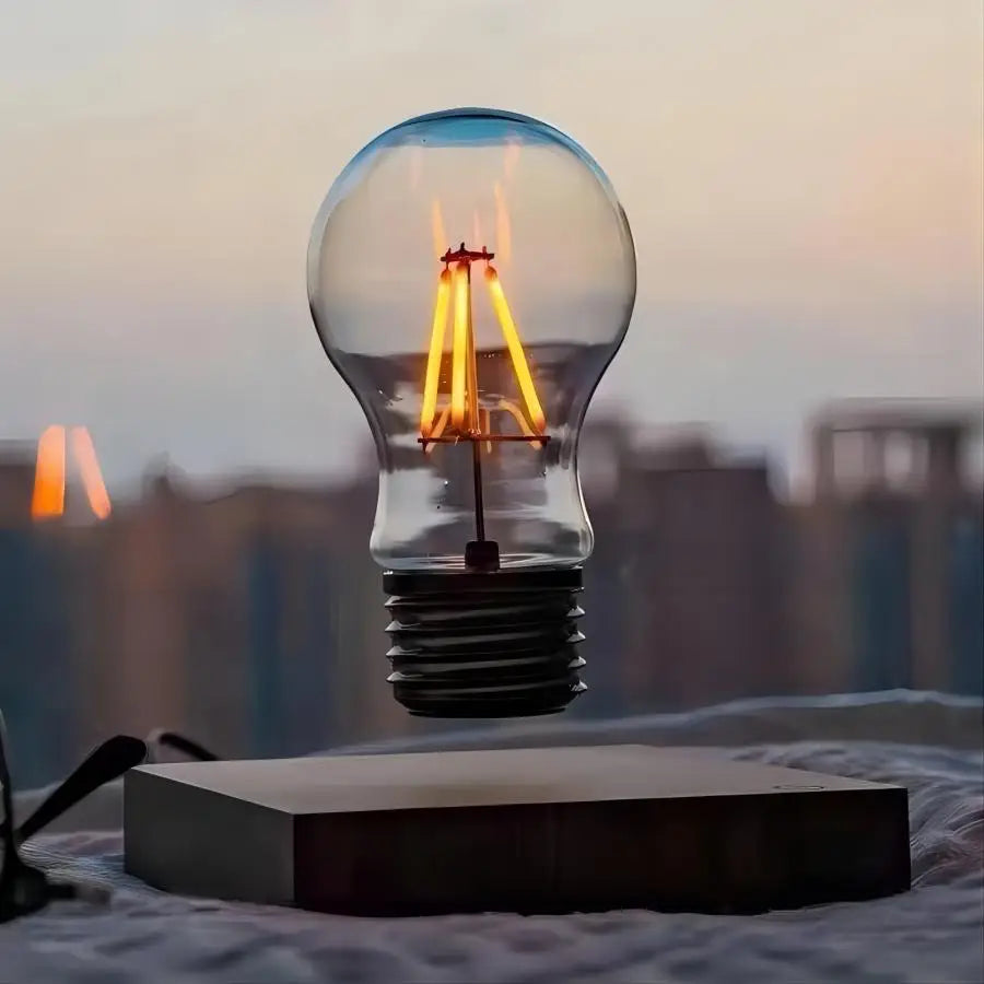 The lit bulb floating above a dark base against a city skyline at dusk