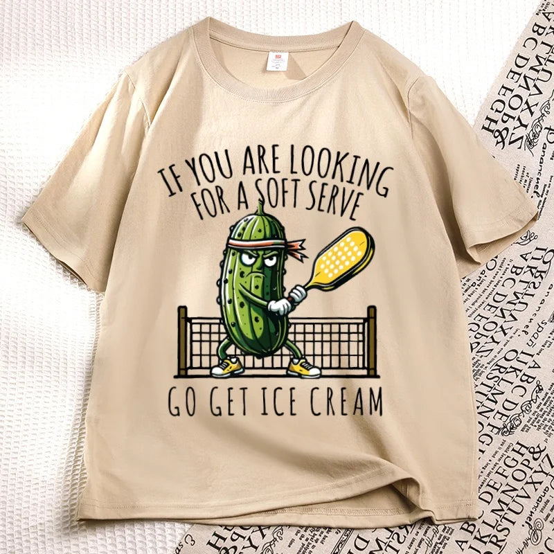 Khaki pickleball tee laid flat, cartoon pickle with a paddle printed on the chest