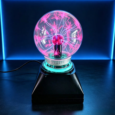 Plasma globe lit with pink filaments on its black base