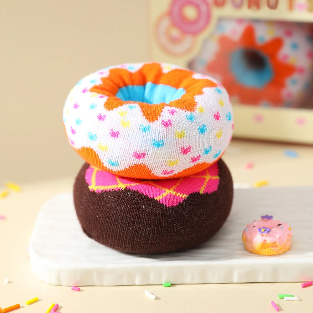 The sprinkled donut sock stacked on top of the pink iced one