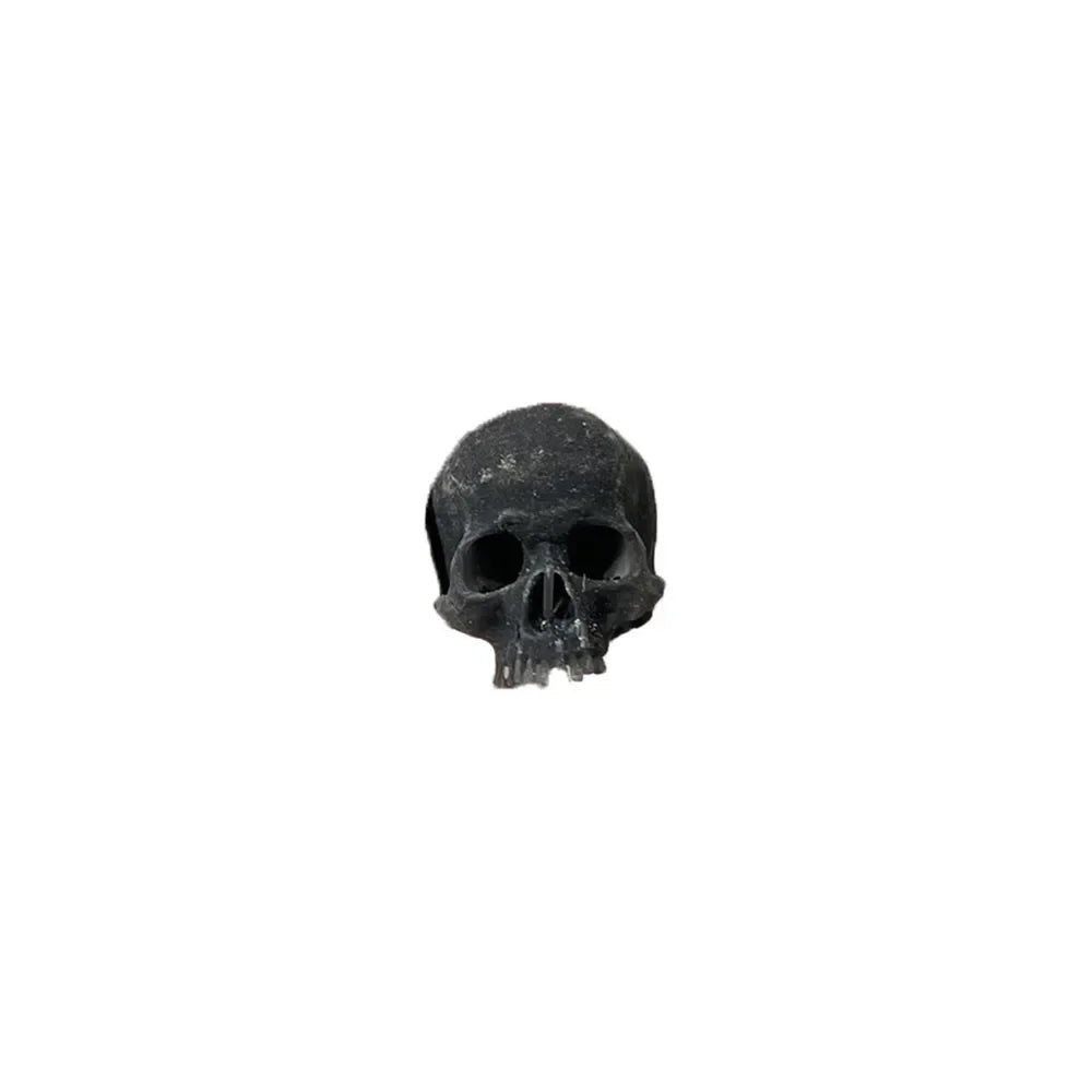 Black: the miniature skull in black plastic on a white background
