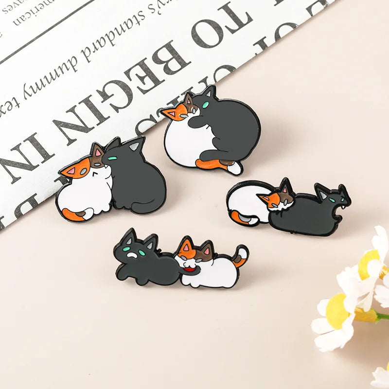 Broche de gato mordiendo a otro gato