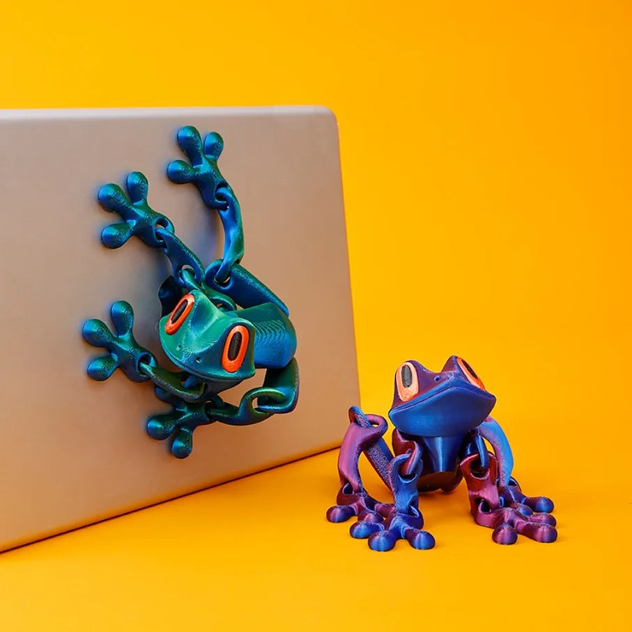 Two frogs gripping the corner of a laptop lid
