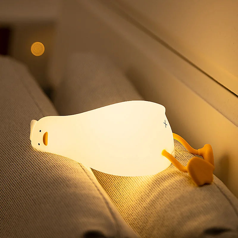 Duck lamp glowing on a bed at night
