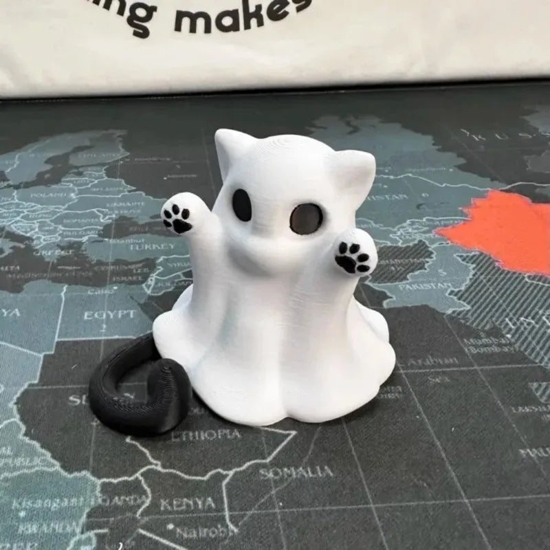 The ghost cat alone on a dark map desk mat, black tail curled out behind