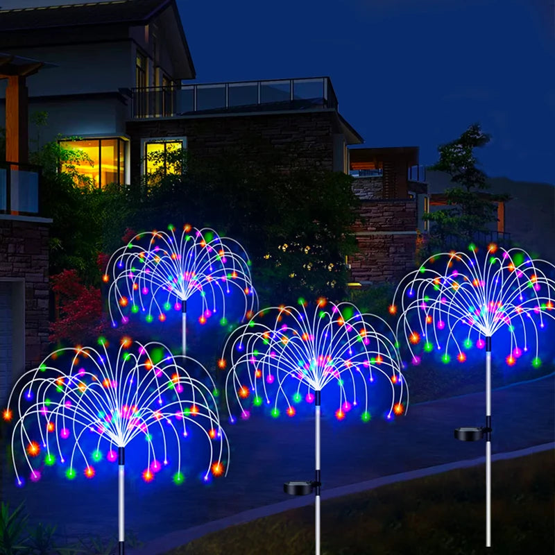 Solar firework stake lights lining a path outside a house after dark