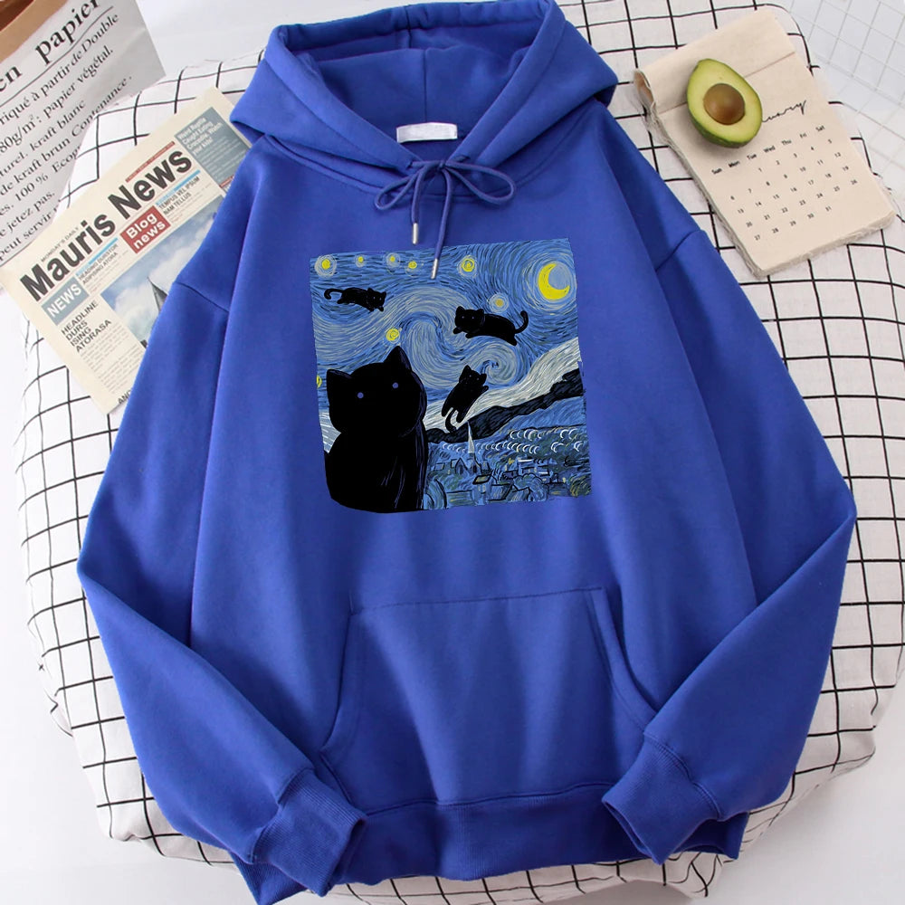 Blue fleece pullover hoodie with a large front print of a swirling starry night sky, a crescent moon and black cats over a village