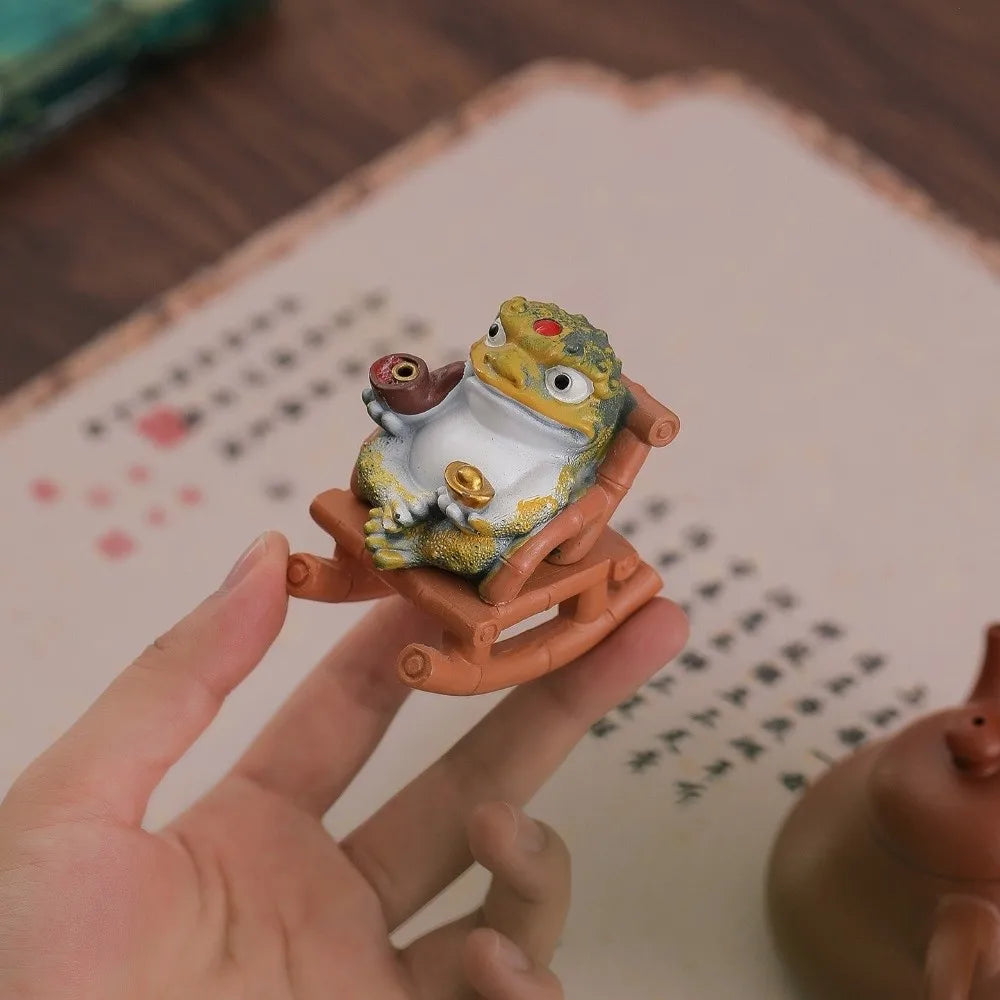 The toad and chair held in a hand to show the scale