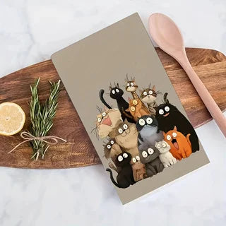 One cat towel folded on a wooden board beside a lemon, a sprig of rosemary and a wooden spoon