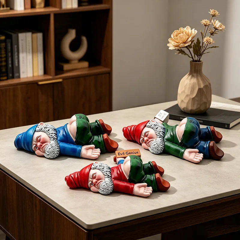 Four passed-out garden gnome figures lying face down on a table beside a vase
