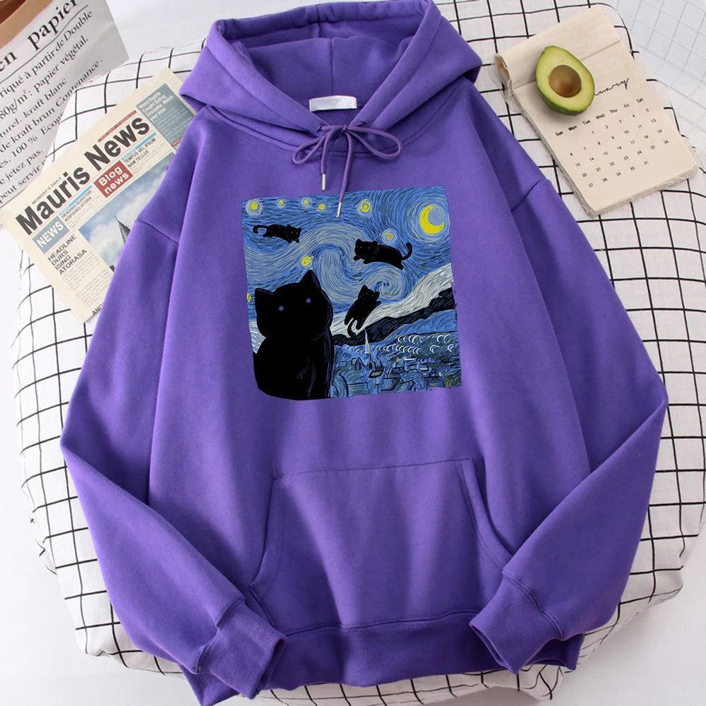 Purple fleece pullover hoodie with a large front print of a swirling starry night sky, a crescent moon and black cats over a village