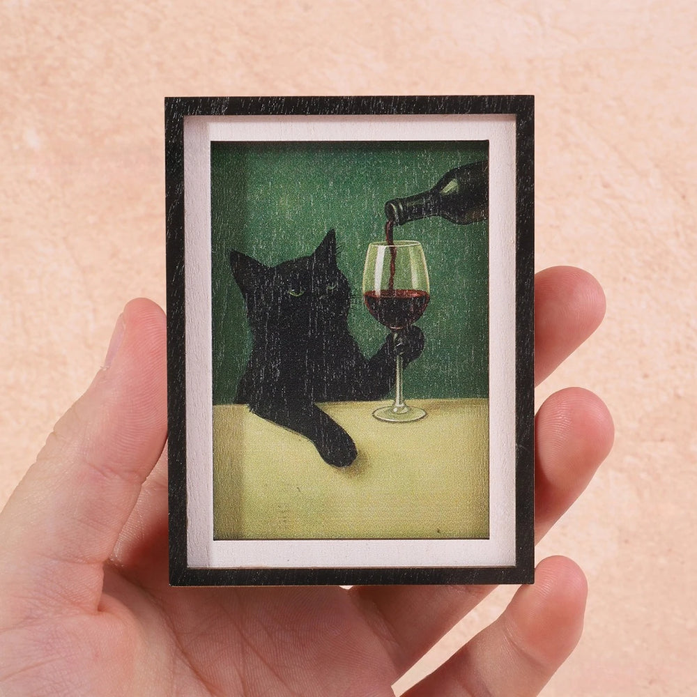 The framed magnet held in a hand to show it is about the size of a credit card