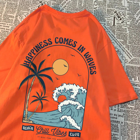 Orange cotton tee with a large back print of a breaking wave, palm trees and a low sun, under the arched words Happiness Comes In Waves