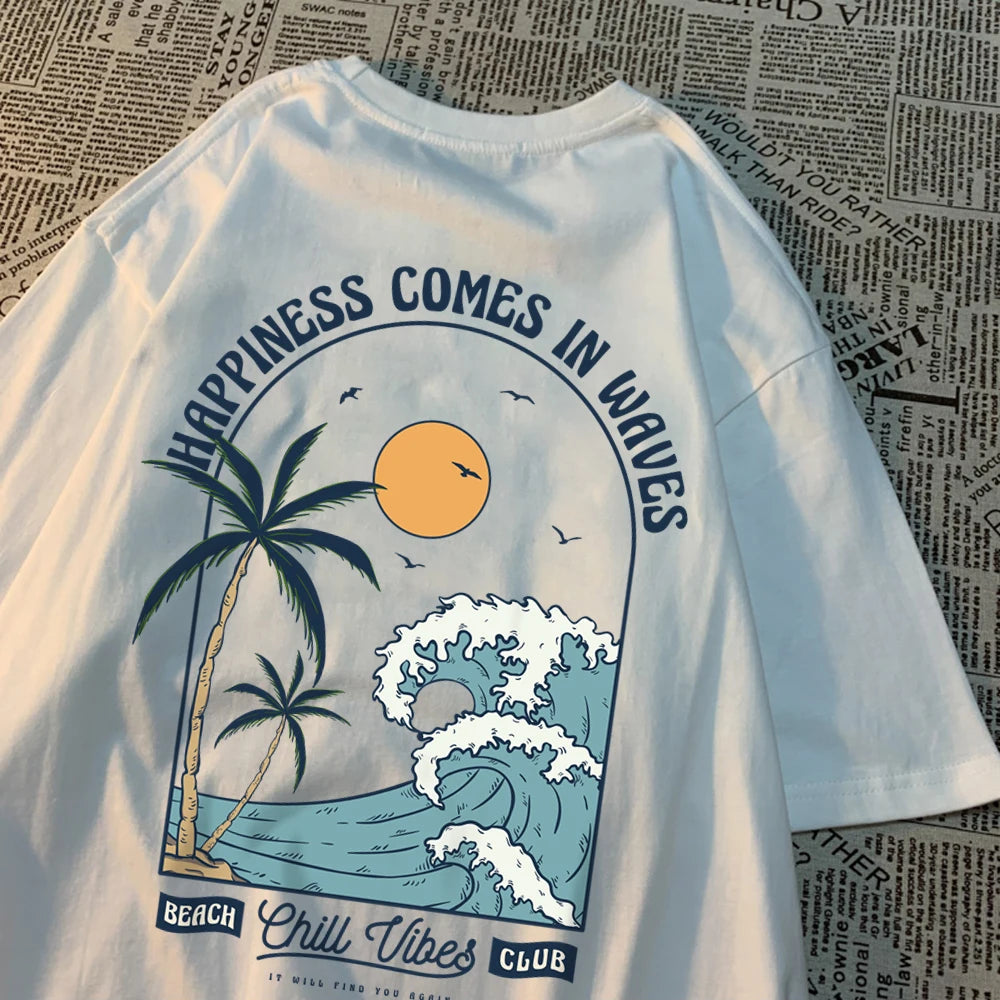 White cotton tee with a large back print of a breaking wave, palm trees and a low sun, under the arched words Happiness Comes In Waves