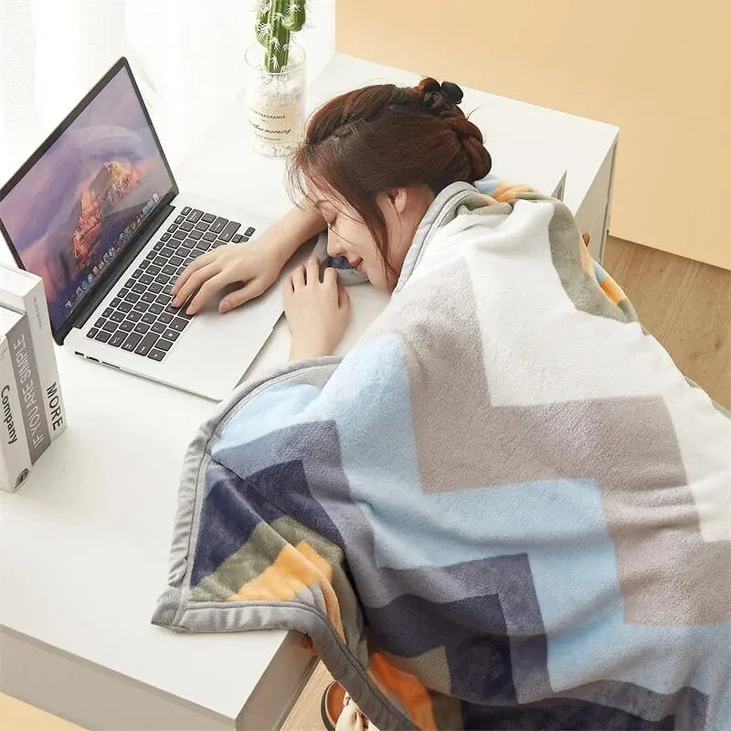 The chevron blanket pulled over someone's shoulders at a desk