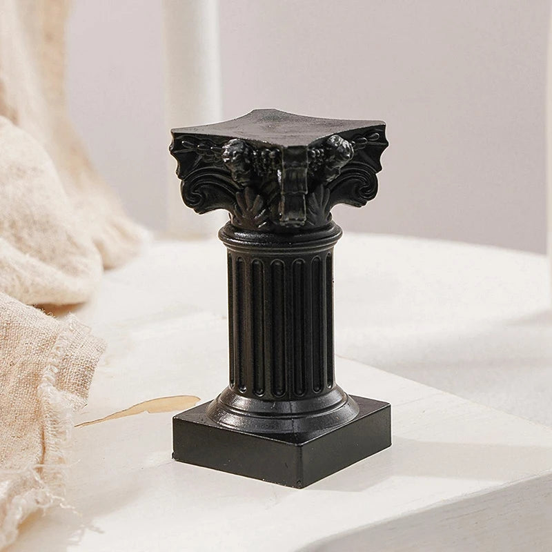 The black column candle holder on a pale cloth