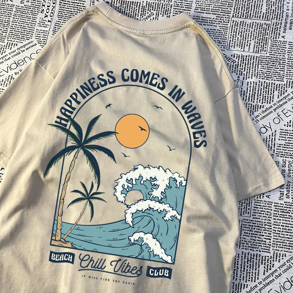 Khaki cotton tee with a large back print of a breaking wave, palm trees and a low sun, under the arched words Happiness Comes In Waves