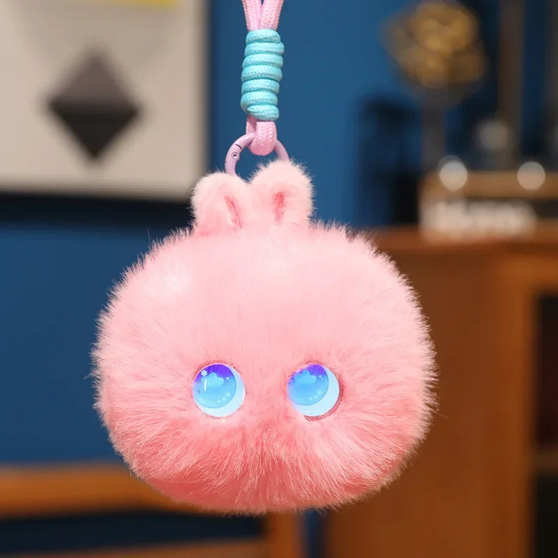 Pink fluffy pom-pom charm with round blue light-up eyes, hanging from its cord