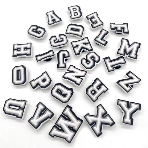 White alphabet letter shoe charms in a pile