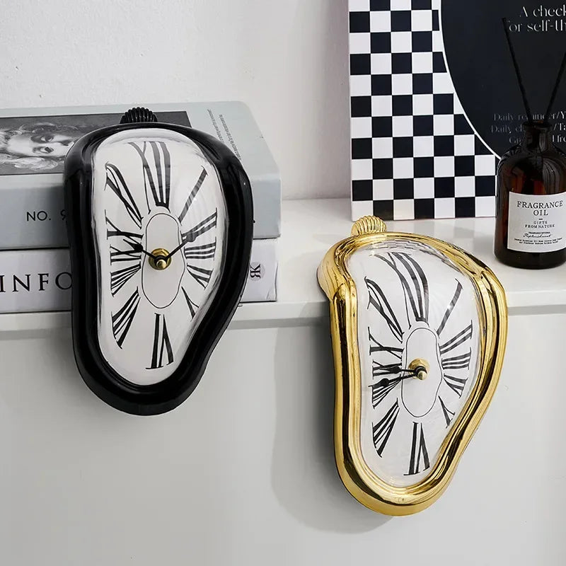 Black and gold melting clocks draped over the edge of a white shelf