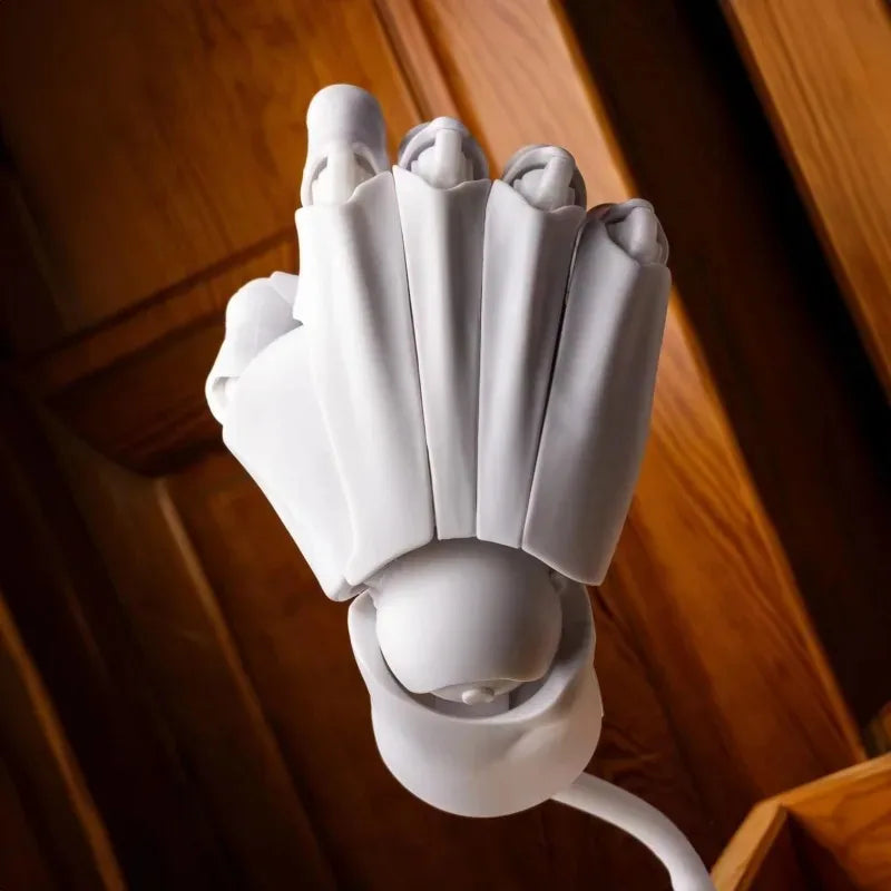 White poseable hand model with the fingers pointing forward, photographed against a wooden door
