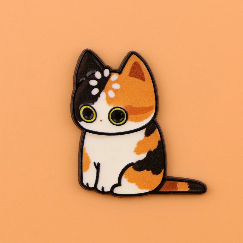 Calico cat magnet in black, ginger and white, with a ring of dots on its head