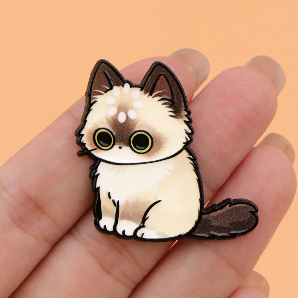 Cream longhair cat magnet held in a hand to show its size