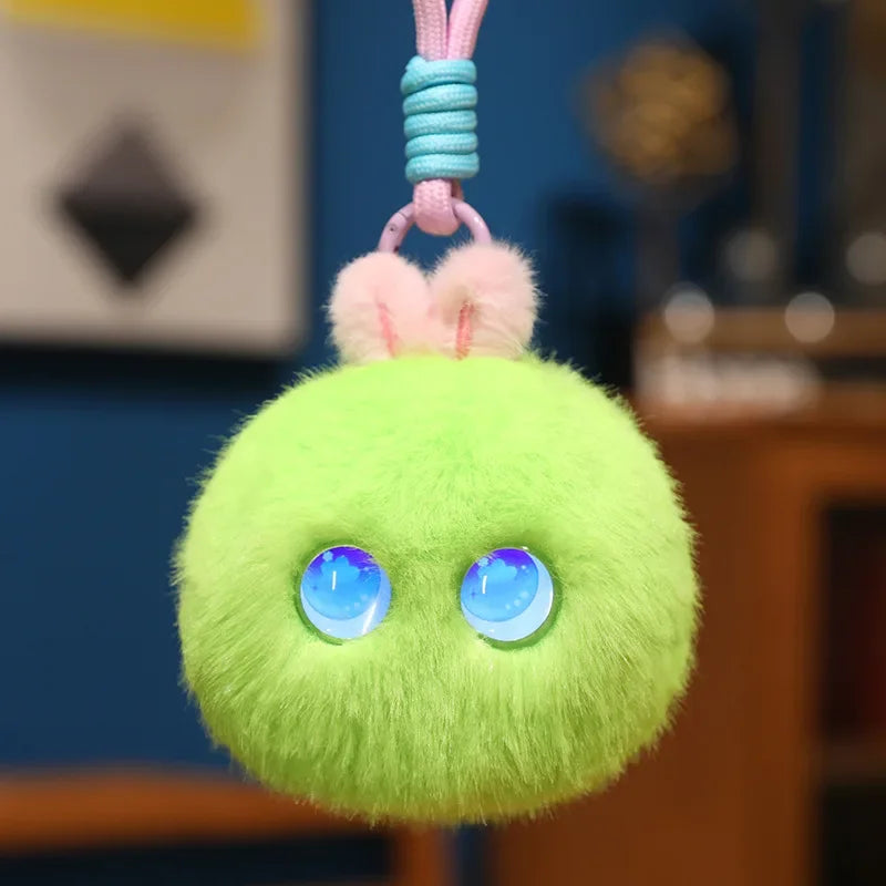 Bright lime green fluffy pom-pom charm with round blue light-up eyes, hanging from its cord