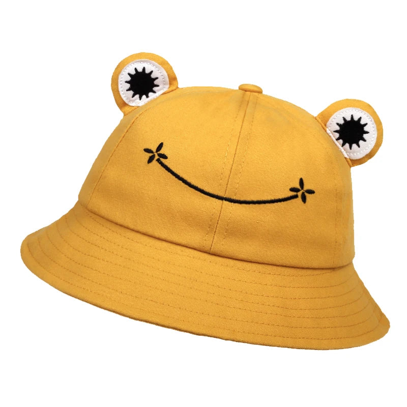 Yellow cotton bucket hat with applique frog eyes and an embroidered smile