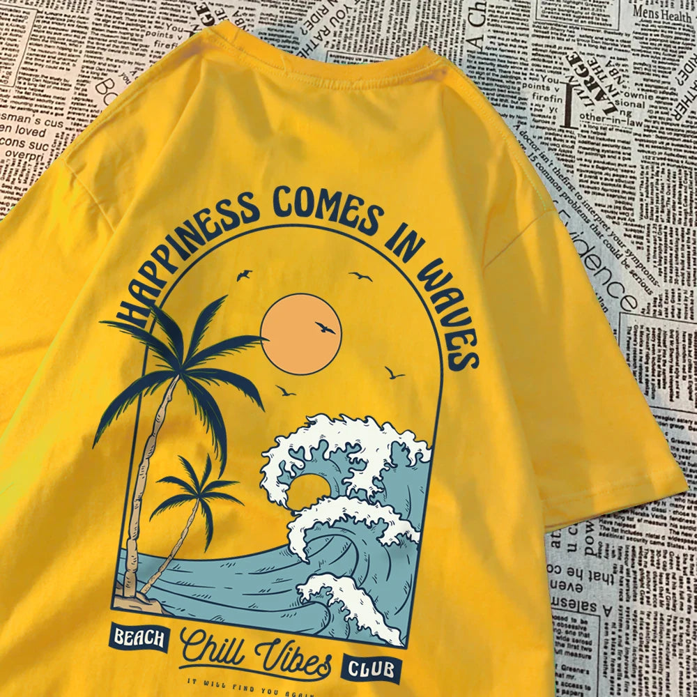 Yellow cotton tee with a large back print of a breaking wave, palm trees and a low sun, under the arched words Happiness Comes In Waves