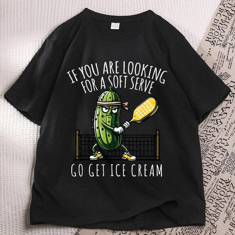 Black pickleball tee laid flat, cartoon pickle with a paddle printed on the chest