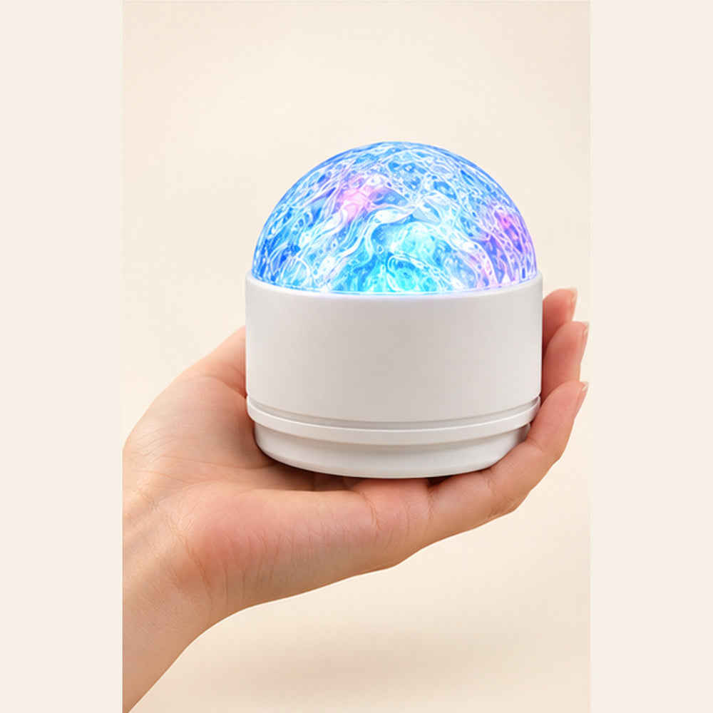 Aurora Wave Ceiling Projector shown in an adult hand for scale