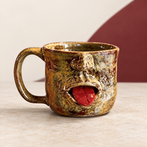 Tongue-Out Face Mug on The Weird Store studio background