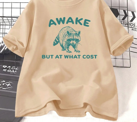 Khaki cotton tee printed with a teal engraved raccoon and the words awake but at what cost