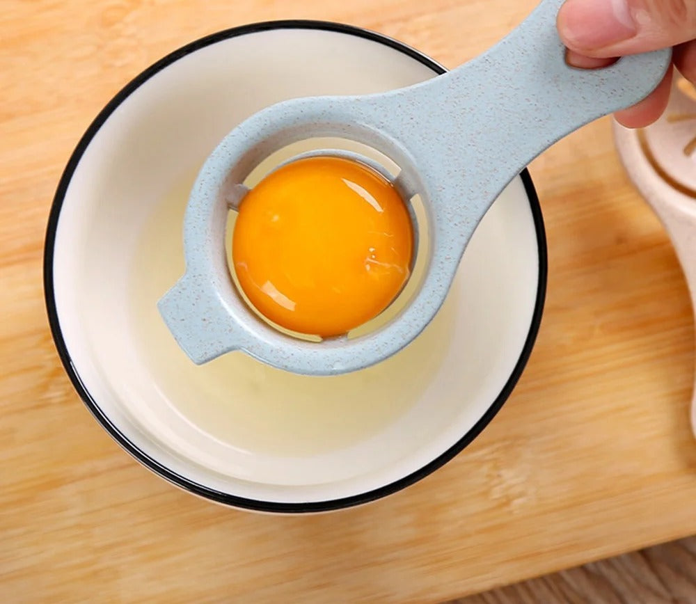 The blue separator held by its handle with a whole yolk sitting in the cup