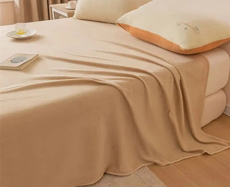 Solid Beige: the blanket spread over a bed in plain beige